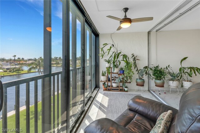 sunroom with a water view and ceiling fan