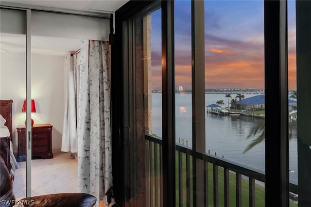 bedroom with multiple windows and a water view