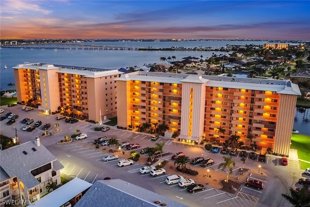 aerial view at dusk featuring a water view