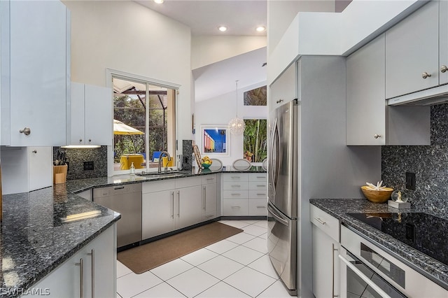 kitchen featuring appliances with stainless steel finishes, backsplash, sink, pendant lighting, and light tile floors