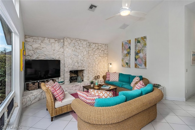 living room with a fireplace, ceiling fan, and light tile floors