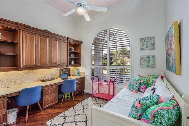 bedroom featuring ornamental molding, dark hardwood / wood-style flooring, ceiling fan, and built in desk