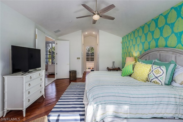 bedroom featuring ceiling fan, dark hardwood / wood-style floors, vaulted ceiling, and ensuite bathroom