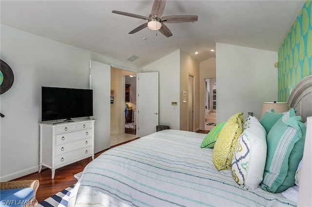 bedroom with a closet, ensuite bathroom, vaulted ceiling, hardwood / wood-style flooring, and ceiling fan