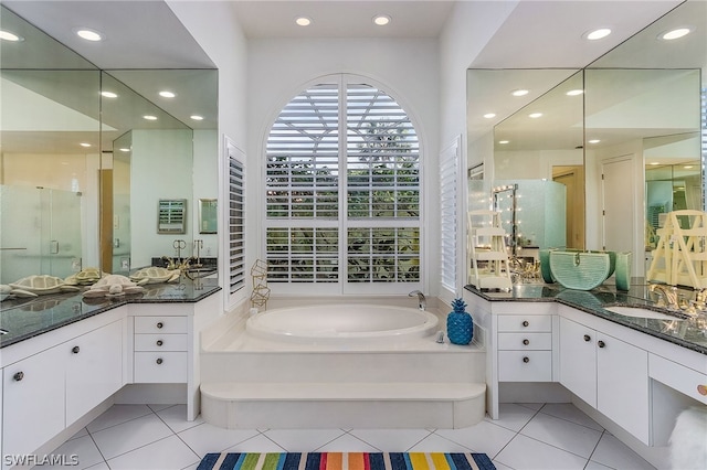 bathroom featuring a bathing tub, tile floors, and vanity with extensive cabinet space