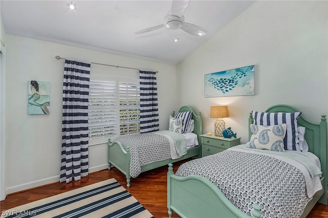 bedroom with ceiling fan, vaulted ceiling, and dark wood-type flooring