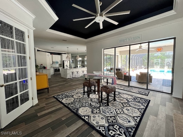 dining space featuring ceiling fan, a tray ceiling, ornamental molding, and hardwood / wood-style floors