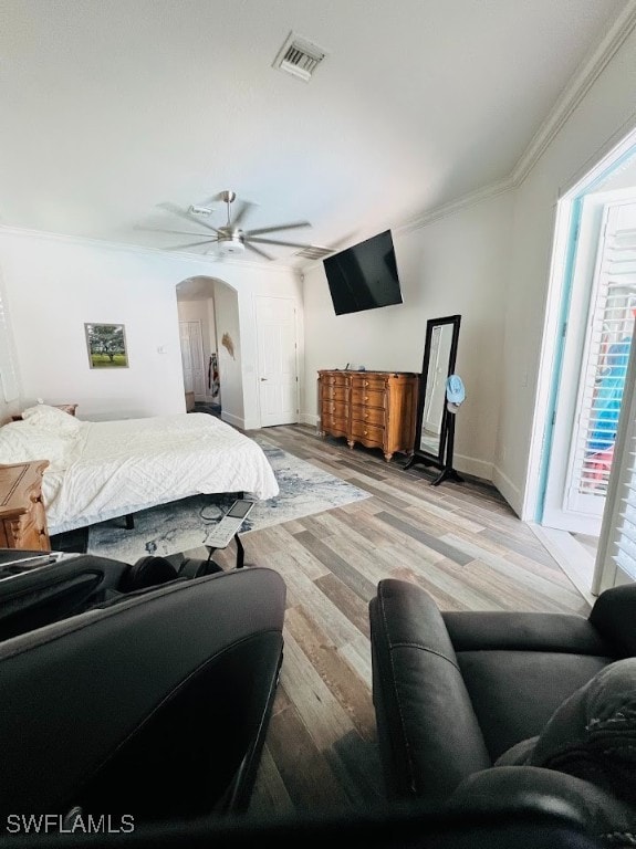 bedroom featuring ceiling fan, crown molding, light wood-type flooring, and multiple windows