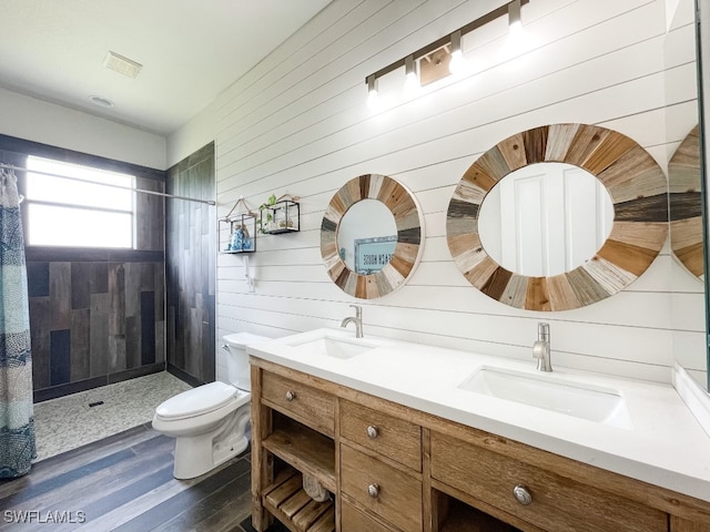 bathroom with hardwood / wood-style floors, wooden walls, toilet, a shower with shower curtain, and dual vanity