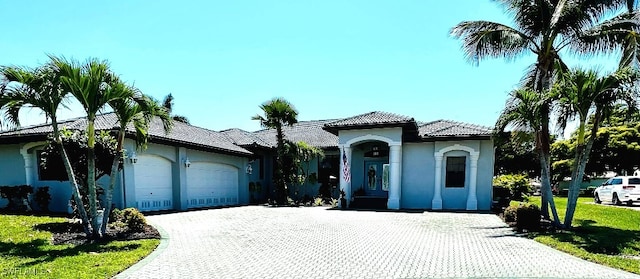 mediterranean / spanish home with a front yard and a garage