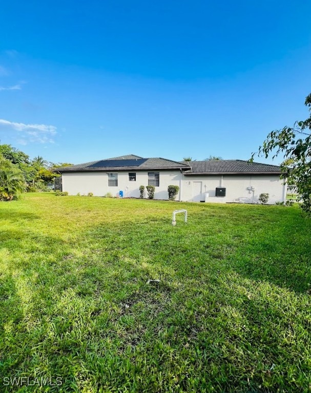 rear view of property featuring a lawn