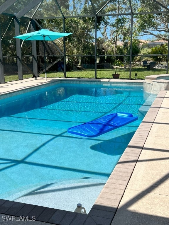 view of swimming pool featuring glass enclosure