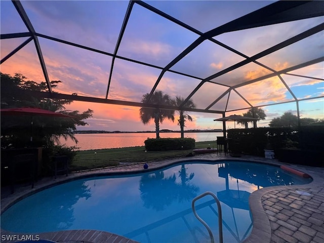 pool at dusk with a water view, a lanai, and a patio area