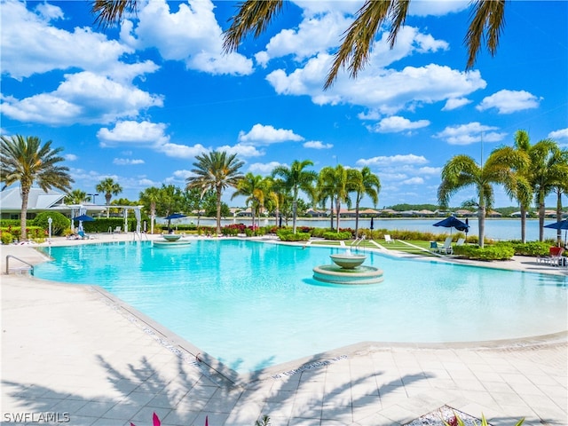 view of swimming pool with a water view and a patio area