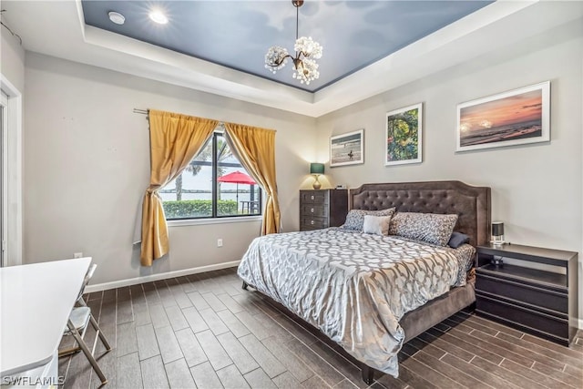 bedroom with a notable chandelier and a tray ceiling