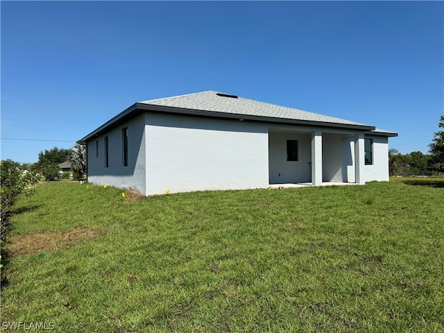 back of house with a lawn