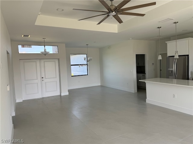 interior space featuring ceiling fan and a tray ceiling