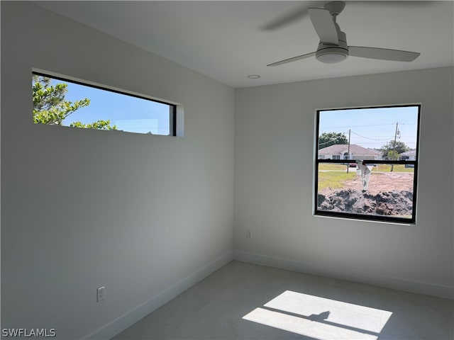 empty room with tile floors and ceiling fan