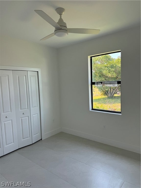 unfurnished bedroom with a closet, ceiling fan, and tile floors