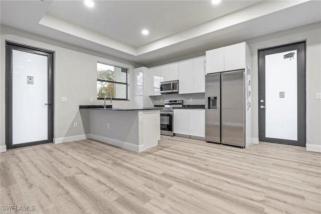 kitchen featuring white cabinets, appliances with stainless steel finishes, and light hardwood / wood-style flooring