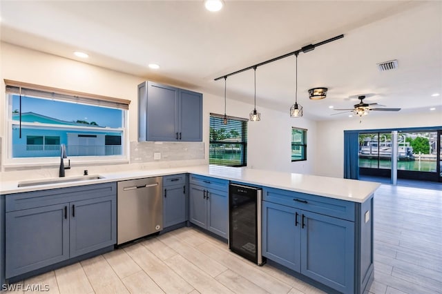 kitchen featuring sink, ceiling fan, dishwasher, beverage cooler, and a wealth of natural light