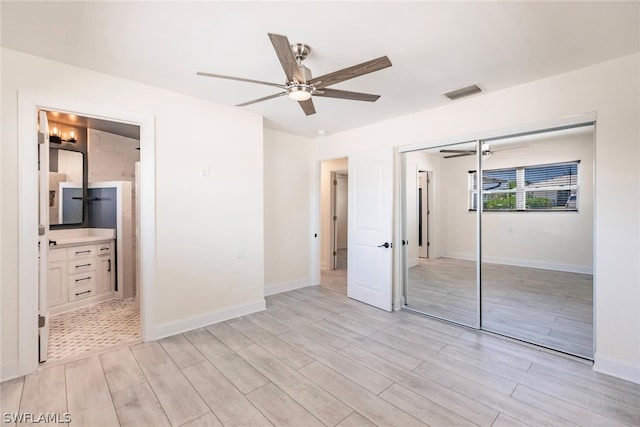 unfurnished bedroom with a closet, light hardwood / wood-style flooring, ceiling fan, and ensuite bathroom