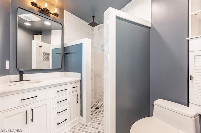 bathroom with large vanity, tiled shower, tile floors, and toilet