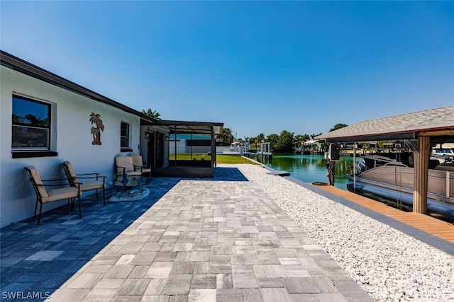 view of patio with a boat dock and a water view