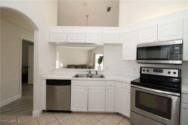 kitchen featuring white cabinets, appliances with stainless steel finishes, sink, and light tile patterned flooring