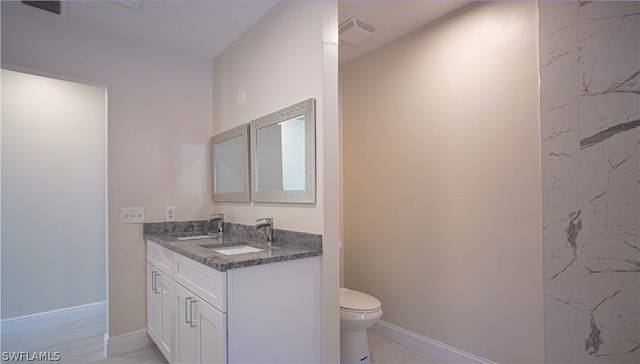 bathroom with vanity, tile floors, and toilet