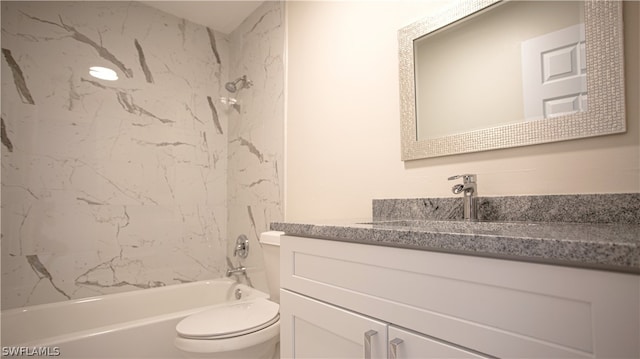 full bathroom featuring vanity with extensive cabinet space, tiled shower / bath, and toilet