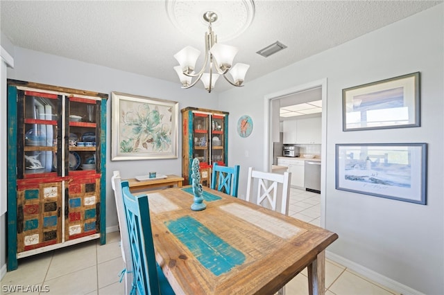 tiled dining room featuring a notable chandelier and a textured ceiling