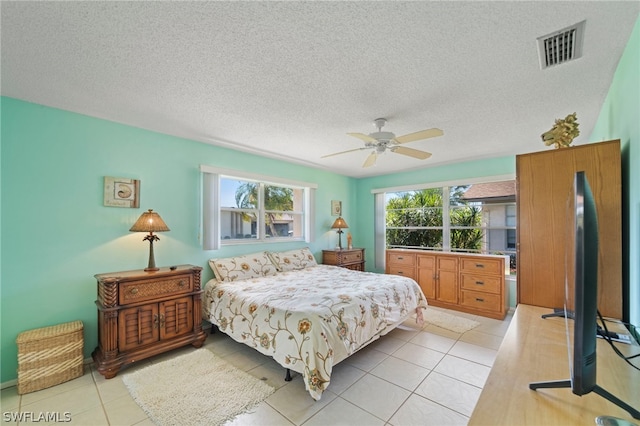 tiled bedroom featuring ceiling fan and a textured ceiling