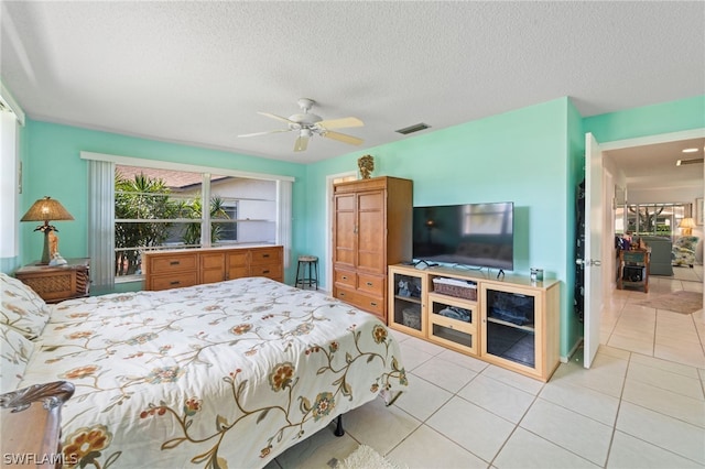 tiled bedroom with a textured ceiling and ceiling fan