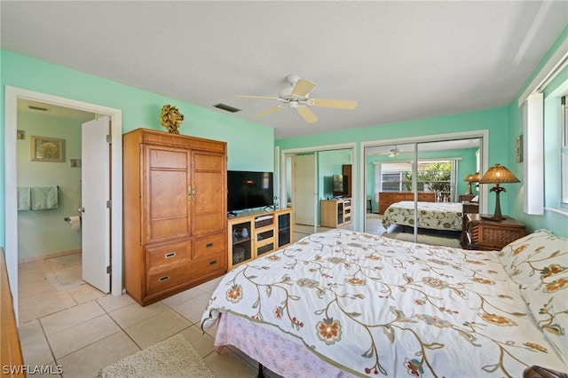 tiled bedroom featuring multiple closets and ceiling fan