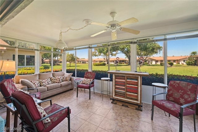 sunroom / solarium featuring a healthy amount of sunlight and ceiling fan