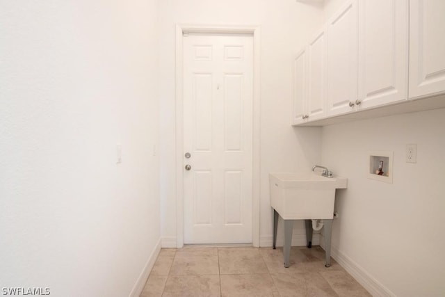 laundry room with cabinets, light tile patterned flooring, and washer hookup