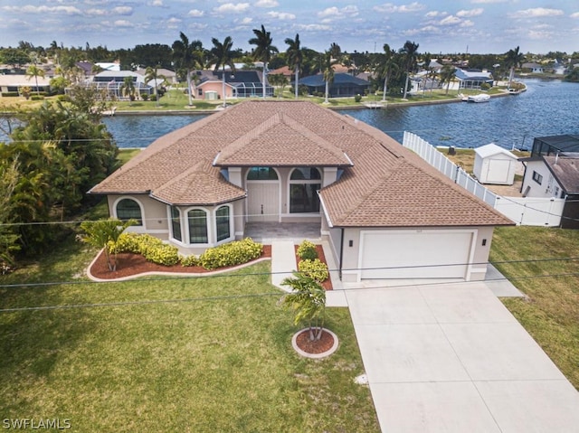 view of front facade featuring a water view, a garage, and a front lawn