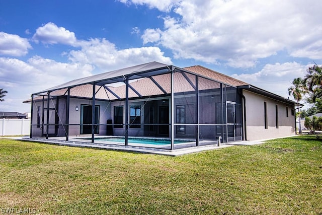 back of house featuring glass enclosure and a lawn