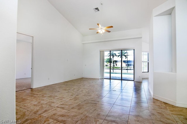 empty room with ceiling fan, high vaulted ceiling, and light tile patterned floors