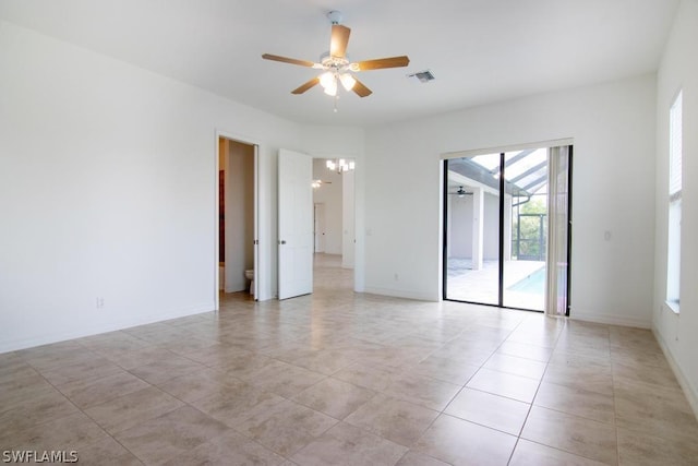 empty room featuring ceiling fan with notable chandelier