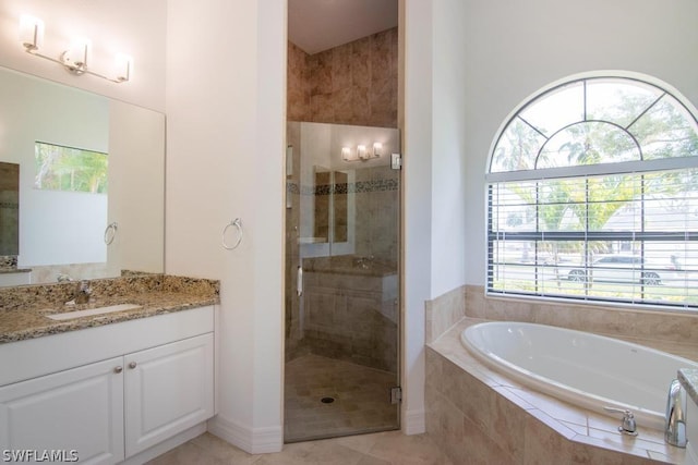 bathroom featuring tile patterned floors, vanity, plenty of natural light, and plus walk in shower