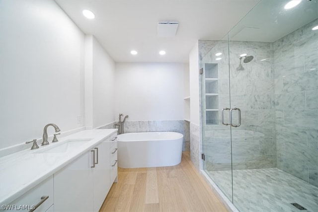 bathroom with vanity, shower with separate bathtub, and hardwood / wood-style flooring