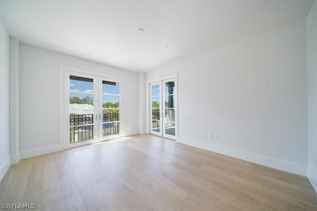 empty room with french doors and light hardwood / wood-style flooring