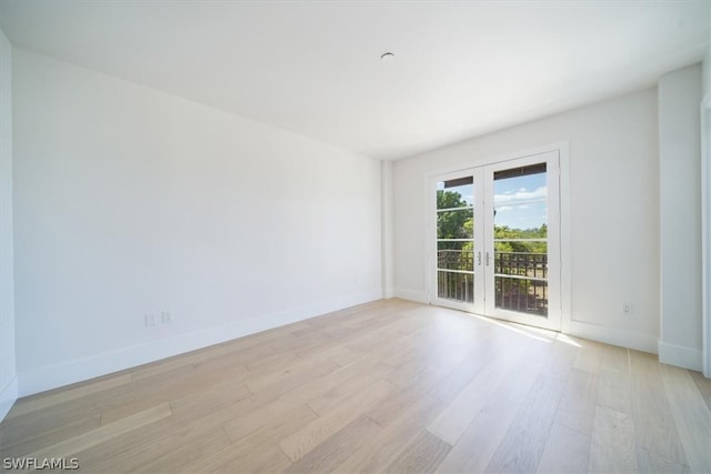 unfurnished room featuring french doors and light hardwood / wood-style flooring