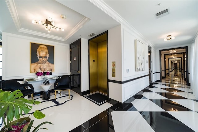 hallway with crown molding, a tray ceiling, elevator, and dark tile floors