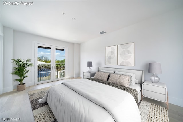 bedroom featuring french doors, hardwood / wood-style flooring, and access to outside