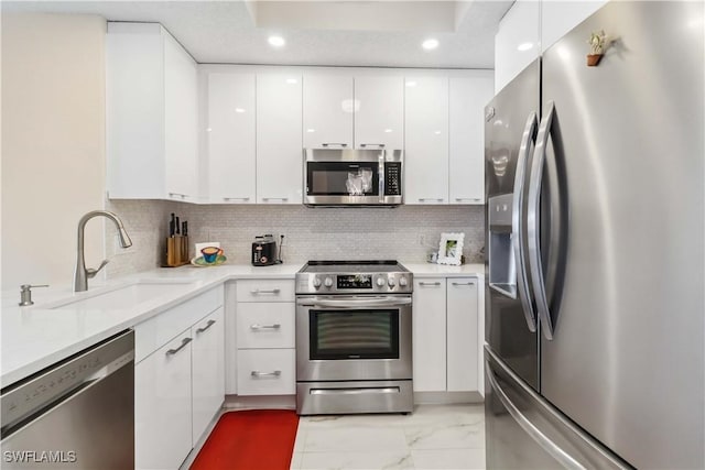 kitchen featuring white cabinetry, sink, decorative backsplash, and appliances with stainless steel finishes