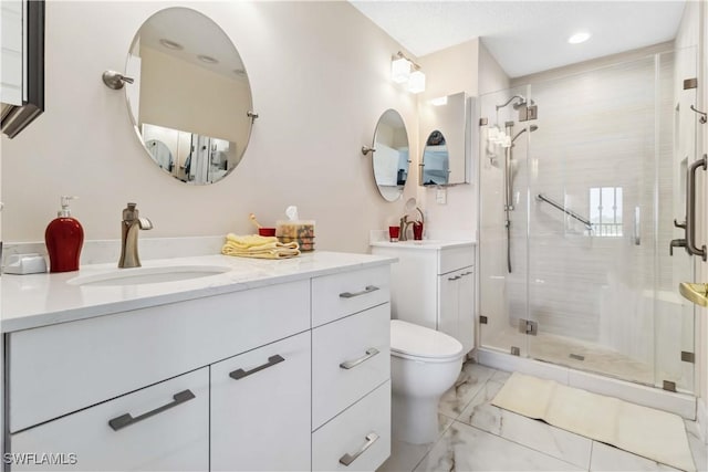 bathroom with vanity, a shower with shower door, and toilet