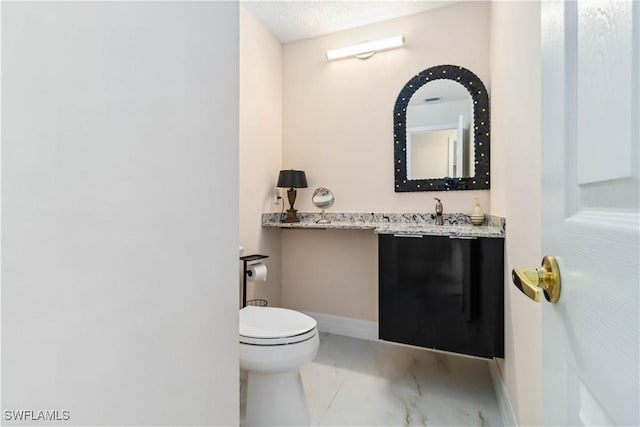 bathroom with vanity, a textured ceiling, and toilet